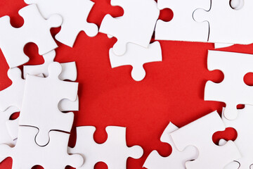 White puzzle pieces on red background, copy space for text.