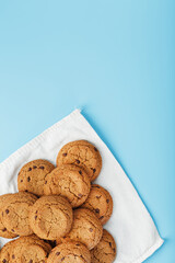 Oatmeal cookies on a blue background and a white napkin top view