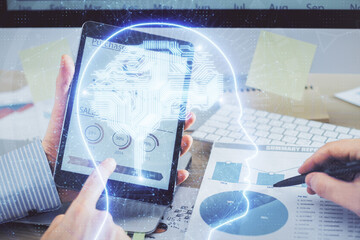 Double exposure of man's hand holding and using a digital device and brain hologram drawing. Data concept.