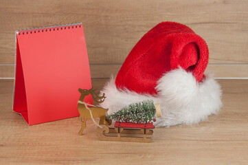 Obraz na płótnie Canvas Blank desk calendar, Santa hat and Christmas decoration. Copy space