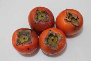 Close up the four delicious oriental persimmons. Japanese persimmon or kaki fruit. Fresh ripe...
