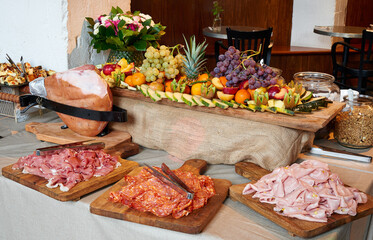 Colored buffet with seasonal fresh fruits and different kind of Ham