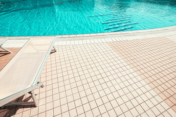 Sun lounge. Summer resort chair, relax lounge at luxury hotel pool. Beach lounger chaise. Vacation sunbed. Blue water, sunny happy travel holiday.