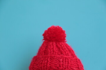 Red wool knit hat. Turquoise blue background. Copy space for text