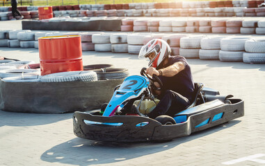 A young man drives a go kart at circuit - obrazy, fototapety, plakaty