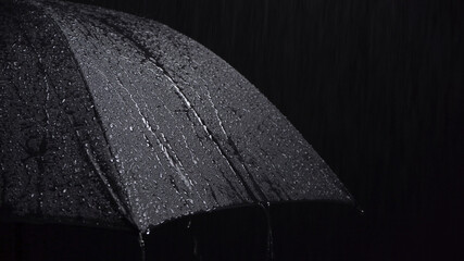 Photo of black umbrella and raindrops on black background