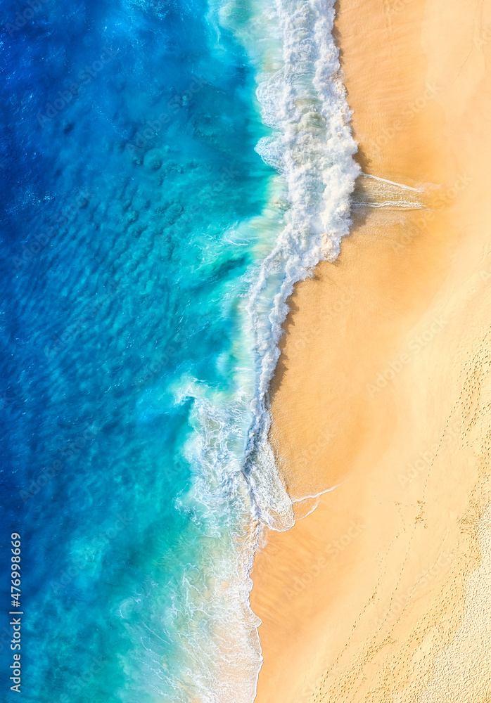 Wall mural beach and waves as a background from top view. blue water background from drone.