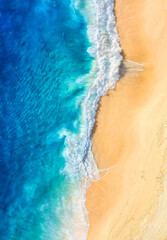 Strand und Wellen als Hintergrund von oben. Hintergrund des blauen Wassers von der Drohne.