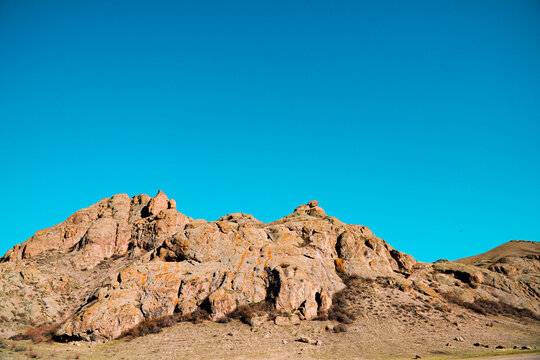 A beautiful view of the red rocky mountain on the blue sky background.