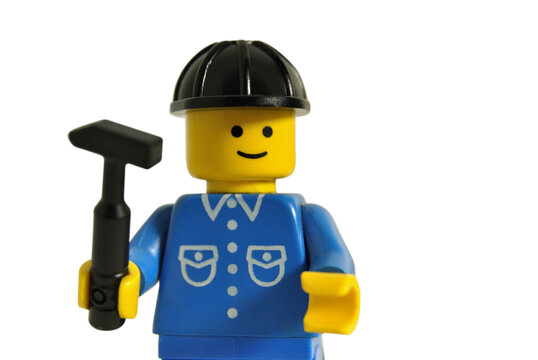 Boneco de lego com uniforme de trabalho azul chapéu de protecção preto e martelo na mão
