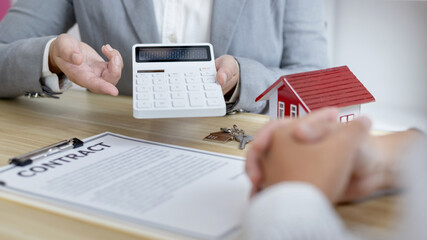 Real estate agent or sales manager talks to clients about the terms of buying a home and collateral...