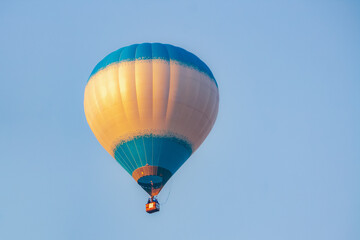 a blue balloon at dawn in the blue sky. the sun's rays are reflected