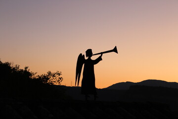 Mountain sunset. Angel sculpture