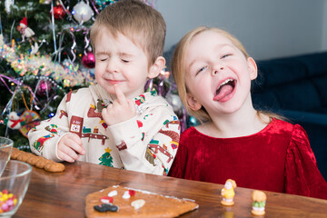children with funny faces decorating gingerbread 