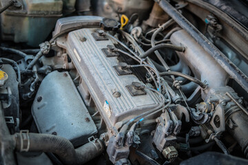 Old dirty engine under the hood of a car
