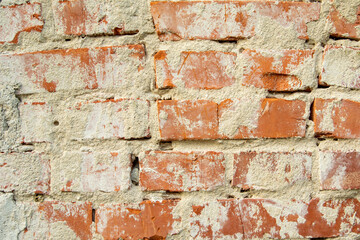 Wall of old red bricks and cement plaster