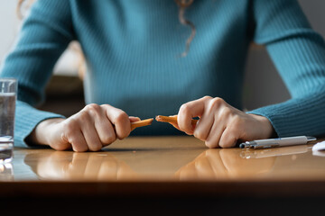 Closeup of outraged female employee breaking pencil siting at office desk. Angry businesswoman boss...