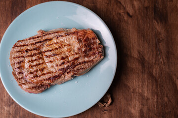 Grilled beef entrecote with flake salt, overhead view.