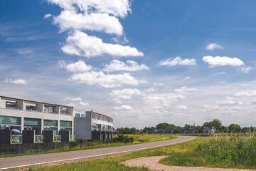 Fototapeta premium Sunny summer day at Netherlands suburb. Modern architecture residential houses and green nature across the road.