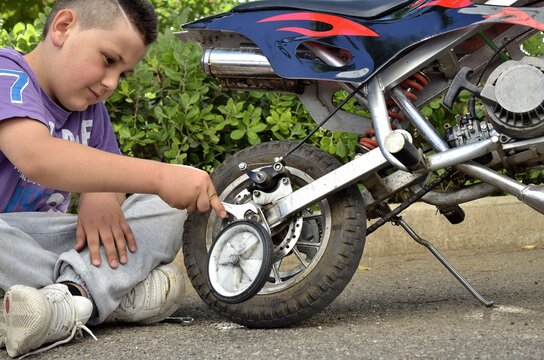Kid maintenance your minimoto &ndash; little boy play with motocross bike young mechanic, adjustment sports moto bike