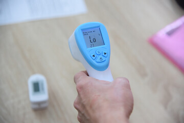 Close-up of the infrared thermometer in the doctor's hand. Temperature measurement in case of viral infection.