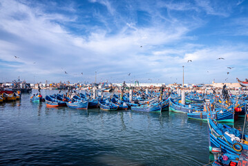 Essaouira, Morocco. October 10, 2021. Small fishing boats moored on coast at port against cloudy...