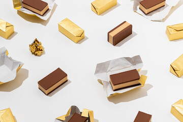 Sweet Belgium pralines with nougat cream in golden foil on white  background.