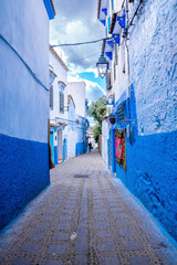 Blue colored residential alley leading to houses on both side, the blue city in the Morocco