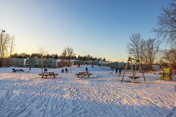 Beautiful view of people on outdoor playground on sunny cold winter day. Sweden. 