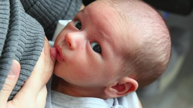 A newborn baby swallows a breast nipple. Close-up