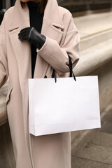 Woman with a white shopping bag on her arm, woman with white shopping bag.