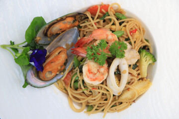 Close up Spicy seafood spaghetti, pasta with shrimp squid shellfish Thai style. Healthy food in Thailand restaurant.