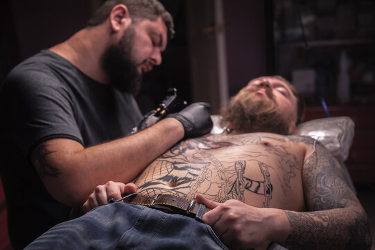 Professional tattooist draws a tattoo