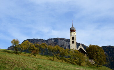 Fototapeta premium St. Valentin Kirche bei Seis am Schlern, Südtirol, Italien, Europa, alte bekannte Kirche mit Fresken auf einer Wiese mit Bäumen im Herbst, Seiser Alm 