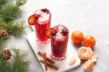 Traditional christmas beverage mulled wine with red cherry juice, orange tangerines, cinnamon...