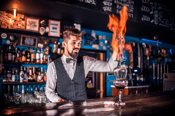 Barman concocts a cocktail behind the bar
