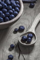 blueberries in wooden bowl and spoon, on old wooden table. Aerial view