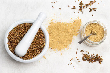 Coriander seeds in wooden mortar.