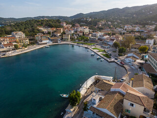 Aerial drone view over Kassiopi marina, iconic small port and fishing village at North of Island of Corfu, Greece.