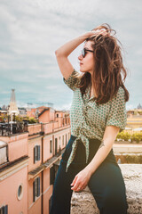 Fototapeta na wymiar Girl, young woman with sunglasses and brown hair от the roof top with beautiful view, Rome, Italy. Vacation in Italy, Europe. Portrait of a beautiful lady.