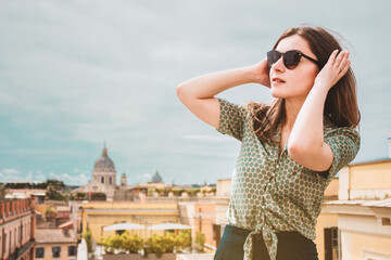 Girl, young woman with sunglasses and brown hair от the roof top with beautiful view, Rome, Italy. Vacation in Italy, Europe. Portrait of a beautiful lady.