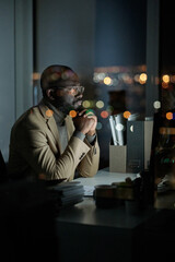 Contemporary manager in formalwear looking through online data on computer screen while working in...