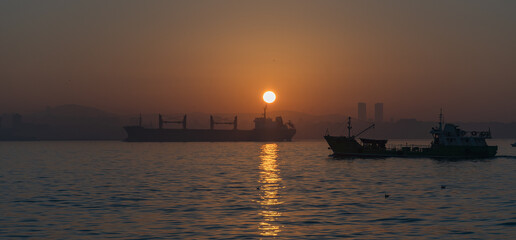 sunrise over the Bosphorus Strait with views from the European side towards Asia. boats under the sunrise sun.