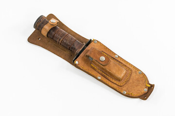 Vintage hunting knife with leather sheath and sharpening stone.