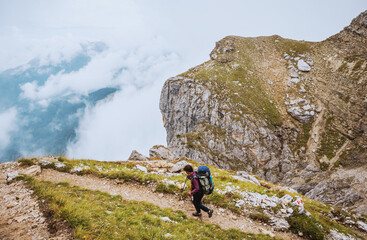 Fototapeta na wymiar Sporty Young woman on mountain trail Dolomites Mountains, Italy