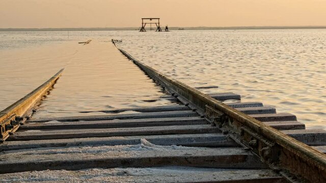 Old train rides on the railway laid in the water through the salt lake. train travels from water. Mined salt in Lake Burlin. Altai. Bursol. Russia. August 2019 