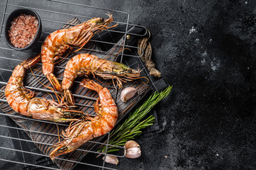 Grilled Giant Black tiger shrimps prawns on grill. Black background. Top view. Free copy space