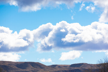 Fototapeta premium fluffy clouds over the mountains