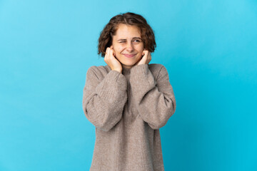 Young English woman isolated on blue background frustrated and covering ears