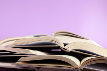 Opened books on pink background. Study, education and back to school concept.